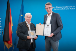 Bavarian Minister of Science Markus Blume (right) presents the award to Rainer Blatt.