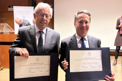 Peter Zoller und Ignacio Cirac halten die Urkunden in der Hand