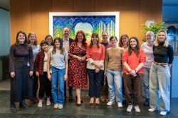 A group of people in front of an painting showing Erwin Schrödinger